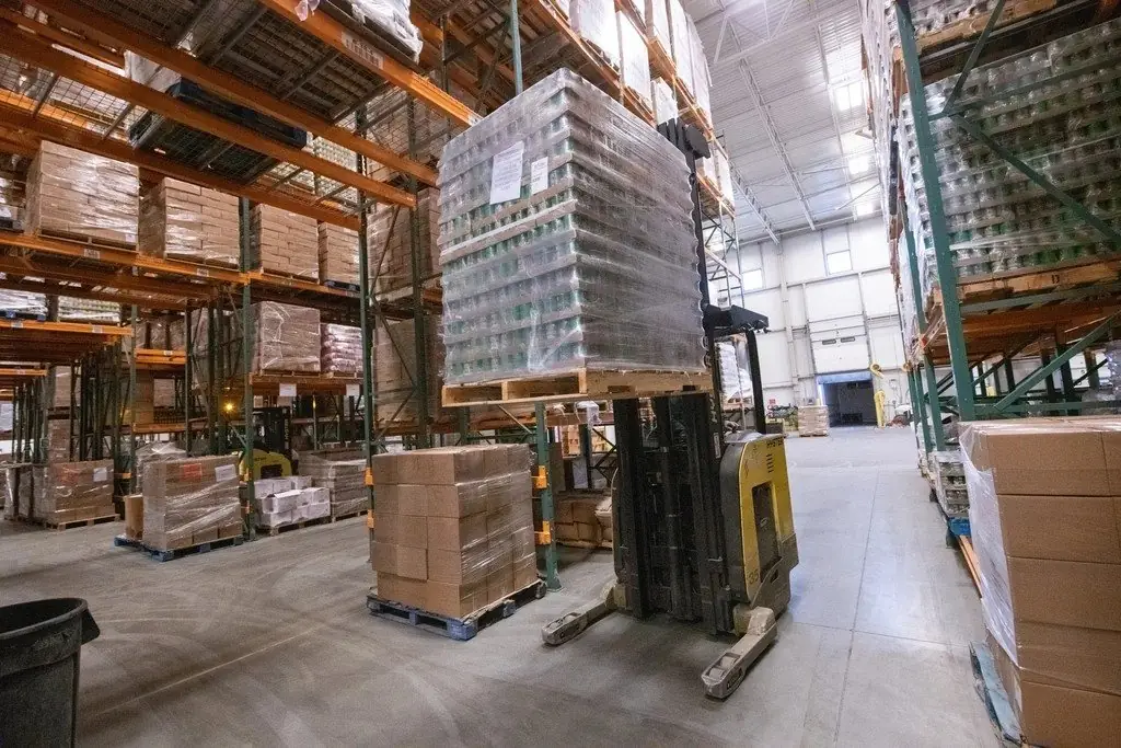 Interior de un centro de distribución con estanterías y tarimas