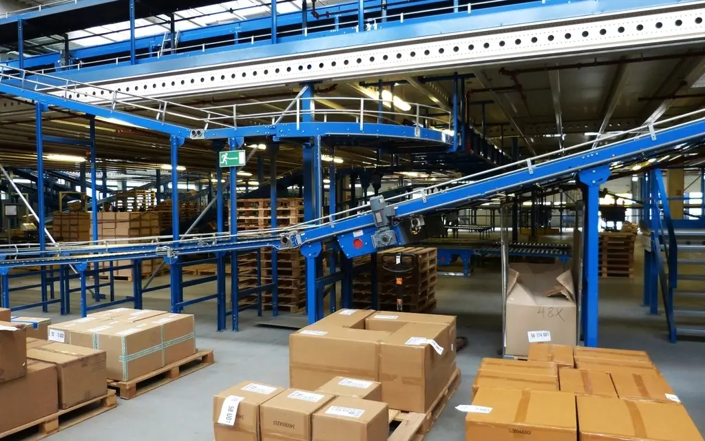 Centro de distribución con bandas transportadoras y tarimas de cajas