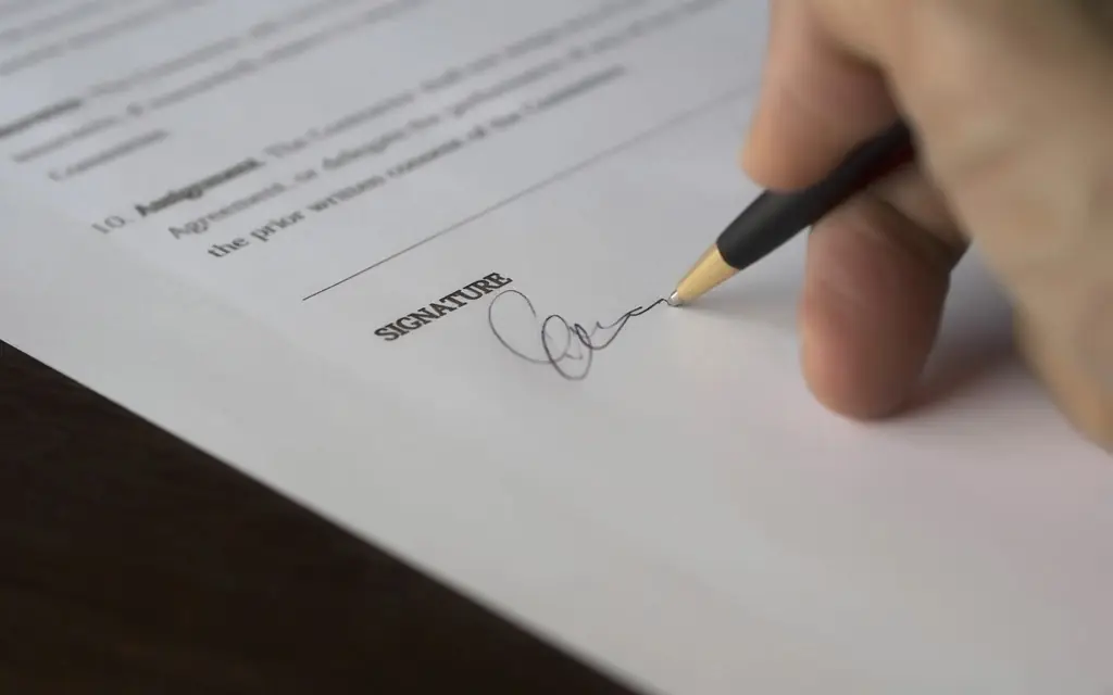 Mano firmando un documento